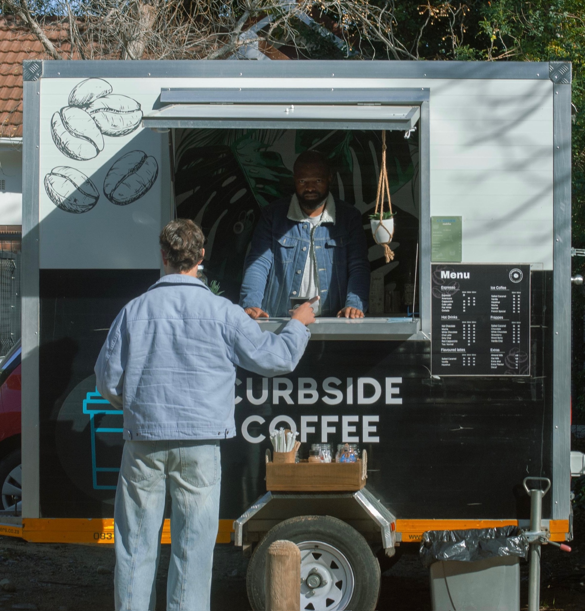 Curbside Coffee barista serving a customer at the trailer