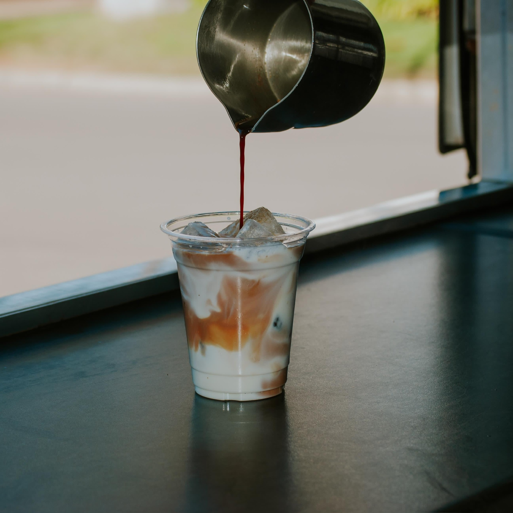Iced latte being prepared inside the Curbside Coffee trailer